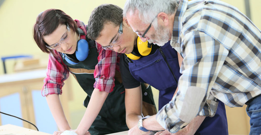 Groupe de jeunes adultes en formation sanitaire et social participant à un atelier pratique encadré par un formateur dans une salle de cours professionnelle